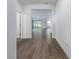 Hallway featuring beautiful wood-look tile flooring, leading to an open-concept living area with a view of the backyard at 10446 Tupper Cay Dr, San Antonio, FL 33576