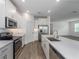 Bright kitchen with stainless steel appliances, white cabinets, quartz countertops, and wood-look tile flooring at 10446 Tupper Cay Dr, San Antonio, FL 33576