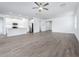 Bright and airy living room with wood-look tile flooring, flowing into the kitchen with white cabinets at 10446 Tupper Cay Dr, San Antonio, FL 33576