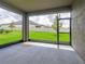 Screened-in patio with gray concrete flooring, offering a view of the green backyard at 10446 Tupper Cay Dr, San Antonio, FL 33576