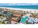 Stunning aerial view of beachfront homes with crystal clear water and a pristine white sand beach at 1058 Eldorado Ave, Clearwater Beach, FL 33767