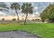Lush backyard featuring well-maintained grass, palm trees, and a serene view of the beach at 1058 Eldorado Ave, Clearwater Beach, FL 33767