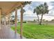 Covered porch overlooking a green lawn with palm trees and a scenic view of the beach at 1058 Eldorado Ave, Clearwater Beach, FL 33767
