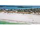 Scenic view of a white sand beach with clear blue waters and waterfront homes in the distance at 1058 Eldorado Ave, Clearwater Beach, FL 33767