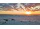 Scenic sunset over a sandy beach with calm waters and distant figures at 1058 Eldorado Ave, Clearwater Beach, FL 33767