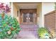 Inviting entryway with a brick path, wooden double doors, and vibrant tropical plants at 1058 Eldorado Ave, Clearwater Beach, FL 33767