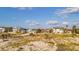 Beautiful houses sit beside sandy dunes under a bright blue sky with fluffy clouds at 1058 Eldorado Ave, Clearwater Beach, FL 33767