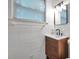 Bathroom with updated sink, wood vanity, and white tile walls at 1069 21St N Ave, St Petersburg, FL 33704