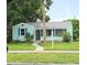 Charming light blue home with green lawn, walkway and mature landscaping at 1069 21St N Ave, St Petersburg, FL 33704