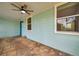 View of the front porch with stone floor, ceiling fan, and blue front door at 1069 21St N Ave, St Petersburg, FL 33704