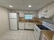 Functional kitchen featuring white appliances, wood countertops, and tile flooring at 107 Caldwell Dr # 178M, Brandon, FL 33510