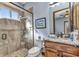 Modern bathroom featuring a glass-enclosed shower, wood cabinets, and granite countertops at 107 Sunset Dr, Nokomis, FL 34275