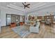 Open-concept living room with wood floors, ceiling fan, and seamless kitchen access at 107 Sunset Dr, Nokomis, FL 34275