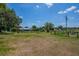 Large backyard with a long wooden fence surrounding the pool, and a home in the distance at 11015 S County Road 39, Lithia, FL 33547