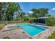 Sparkling pool and spa with a screened-in porch and trees enhancing outdoor living at 11015 S County Road 39, Lithia, FL 33547