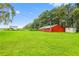 Spacious, red barn on a lush green field provides ample storage and rustic charm at 11015 S County Road 39, Lithia, FL 33547