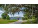 Charming single-story home features a metal roof, mature trees, and a well-manicured lawn at 11015 S County Road 39, Lithia, FL 33547