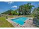 An inviting in-ground swimming pool with a spa and brick patio is surrounded by lush greenery at 11015 S County Road 39, Lithia, FL 33547