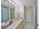 Neutral bathroom features a large mirror with vanity lighting, a long vanity, and a blue shower curtain at 11029 Winter Crest Dr Dr, Riverview, FL 33569