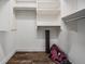 Neat walk-in closet with shelving, hanging racks, and wood-look flooring at 1119 Hounds Run, Safety Harbor, FL 34695