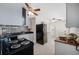 Bright kitchen with black appliances, stone backsplash, and grey cabinets at 1120 45Th N St, St Petersburg, FL 33713