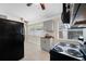 Kitchen featuring black appliances, gray cabinets, ceiling fan and natural light from large windows at 1120 45Th N St, St Petersburg, FL 33713