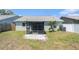 Backyard featuring a screened-in patio and a grassy area with a tree and AC unit at 11226 Thicket Ct, Tampa, FL 33624