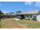 Spacious backyard featuring a screened lanai, a combination of green and dry grass, and a light gray privacy fence at 11226 Thicket Ct, Tampa, FL 33624