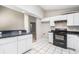 Functional kitchen featuring white cabinets, black appliances, and durable tile flooring at 11226 Thicket Ct, Tampa, FL 33624