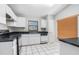 Bright kitchen featuring white cabinetry, black countertops, and tile flooring at 11226 Thicket Ct, Tampa, FL 33624