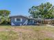 View of a single-story home with a covered area, landscaping, and a well-maintained lawn at 11397 122Nd Ave, Largo, FL 33778