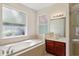 Bathroom featuring a soaking tub, tiled walls, and vanity with sink at 12817 Darby Ridge Dr, Tampa, FL 33624