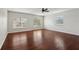 Bright bedroom with hardwood floors, ceiling fan, and large windows offering lots of natural light at 12817 Darby Ridge Dr, Tampa, FL 33624