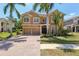 Stunning two-story home featuring lush landscaping, a paver driveway, and a two-car garage at 12817 Darby Ridge Dr, Tampa, FL 33624