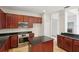 Well-equipped kitchen featuring dark wood cabinets, granite countertops, and stainless steel appliances at 12817 Darby Ridge Dr, Tampa, FL 33624
