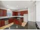 Kitchen features dark wood cabinetry, granite countertops, stainless appliances and an island at 12817 Darby Ridge Dr, Tampa, FL 33624