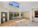 Expansive living room with high ceilings, travertine floors, and access to the pergola-covered patio at 12817 Darby Ridge Dr, Tampa, FL 33624