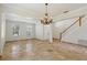 Bright living room with travertine flooring, a chandelier, and a staircase at 12817 Darby Ridge Dr, Tampa, FL 33624