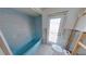 Picture showcasing the bathroom with the blue bathtub, toilet, and backdoor; needs a complete remodel at 1311 Sea Gull S Dr, St Petersburg, FL 33707