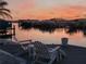 Picturesque waterfront view with a dock, boats, lounge seating, and tranquil sunset ambiance at 1311 Sea Gull S Dr, St Petersburg, FL 33707