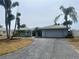 Charming single-story home with a paved driveway and lush tropical landscaping featuring mature palm trees at 1311 Sea Gull S Dr, St Petersburg, FL 33707