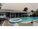 Backyard features a pool, hot tub, screened patio, and lush landscaping with a rainbow overhead at 1311 Sea Gull S Dr, St Petersburg, FL 33707