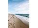 Picturesque beach view with gentle waves, sandy shore, and footprints in the sand at 1427 Gerard Ln, Holiday, FL 34690