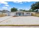 Charming single-story home featuring a minimalist landscape, garage, and blue accent door at 1427 Gerard Ln, Holiday, FL 34690