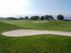 Scenic golf course view featuring lush green grass, trees, and sand traps near the ocean at 1427 Gerard Ln, Holiday, FL 34690