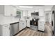 Updated kitchen with stainless steel appliances, white subway tiles, and black hardware at 1427 Gerard Ln, Holiday, FL 34690