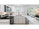 Modern kitchen boasts white cabinets, stainless steel appliances, and sleek countertops for a clean, contemporary look at 1601 54Th S St, Gulfport, FL 33707