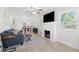 Inviting living room featuring a brick fireplace, ceiling fan, and an open layout leading to the kitchen at 1601 54Th S St, Gulfport, FL 33707