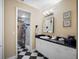 Bathroom showcasing a vanity with a black countertop and walk-in shower with black accents at 1702 Cordova Green, Seminole, FL 33777