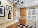 Bright kitchen area showcasing granite countertops, wooden cabinets and a black and white tile floor at 1702 Cordova Green, Seminole, FL 33777